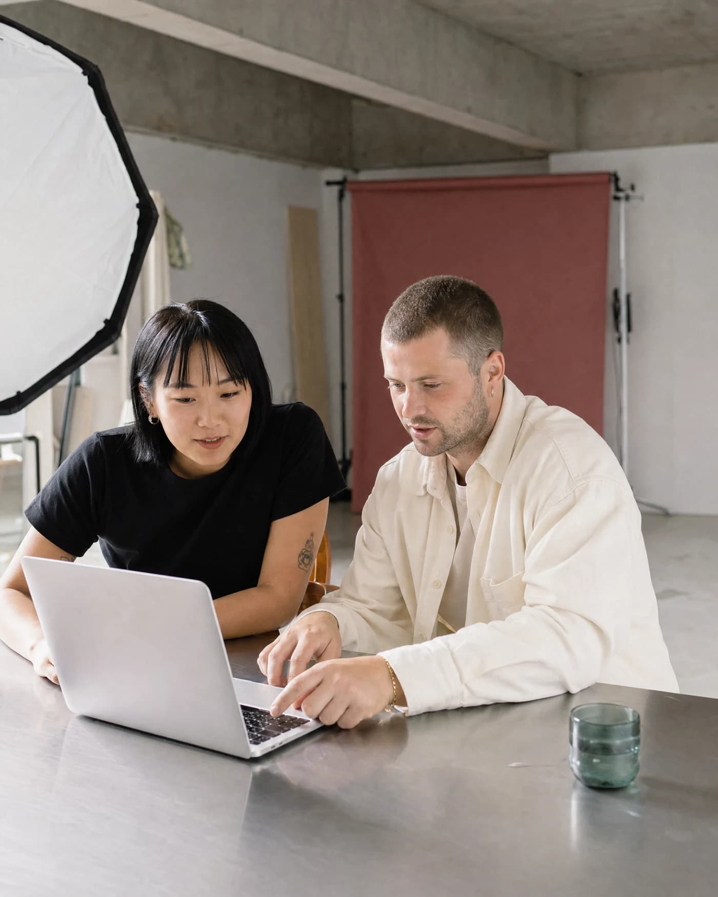 Creative collaborators reviewing footage in a daylight studio